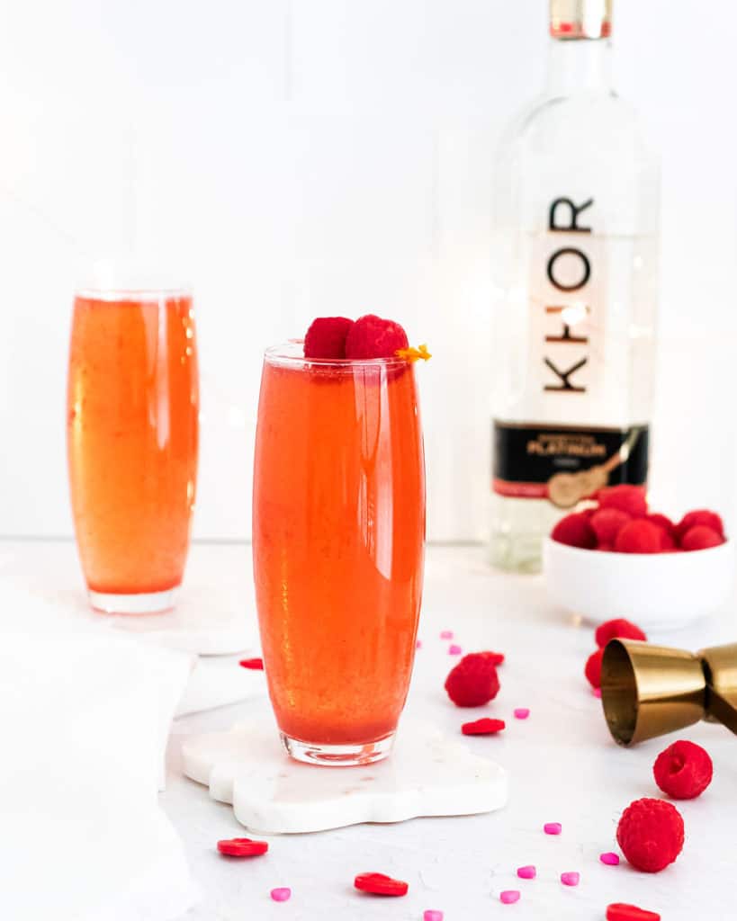 Raspberry Rosé Spritzer on white table with vodka and raspberries
