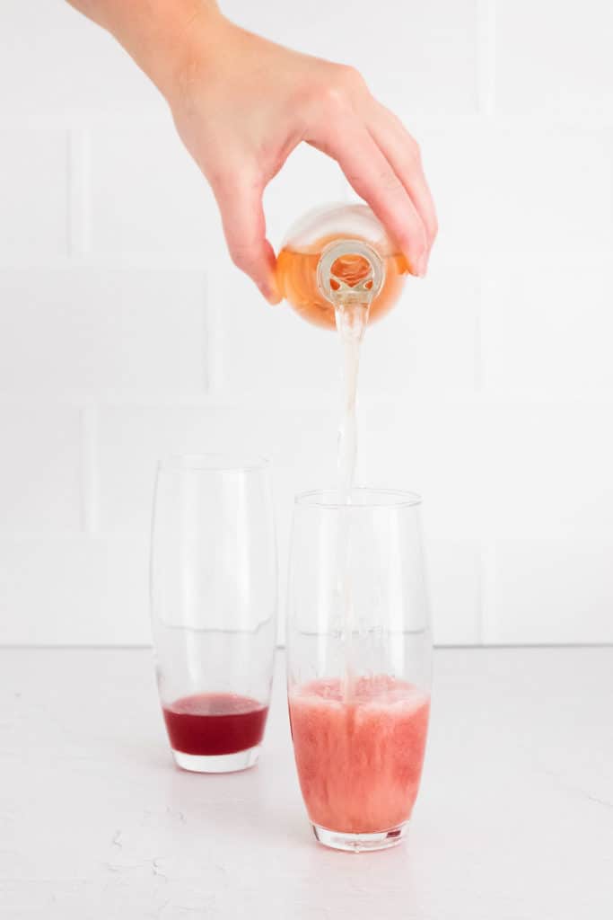 sparkling rose being poured into muddled mint and raspberries