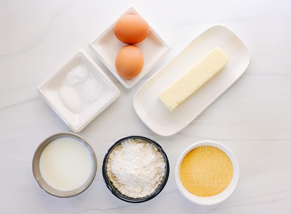 ingredients for cornmeal pancakes on white table