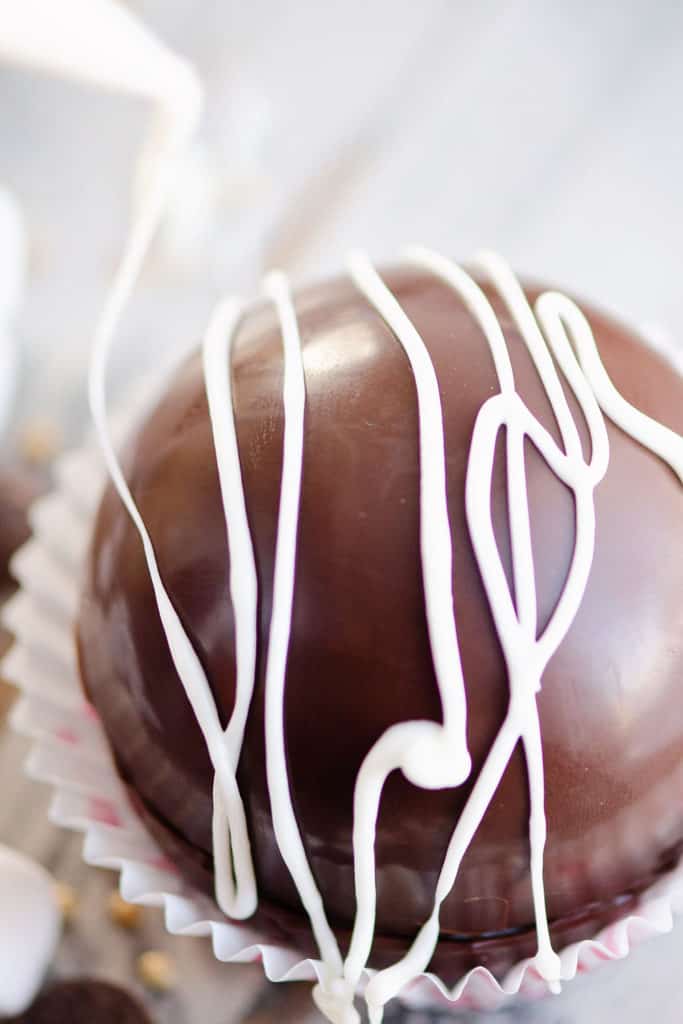 hot cocoa bombs drizzled with white chocolate