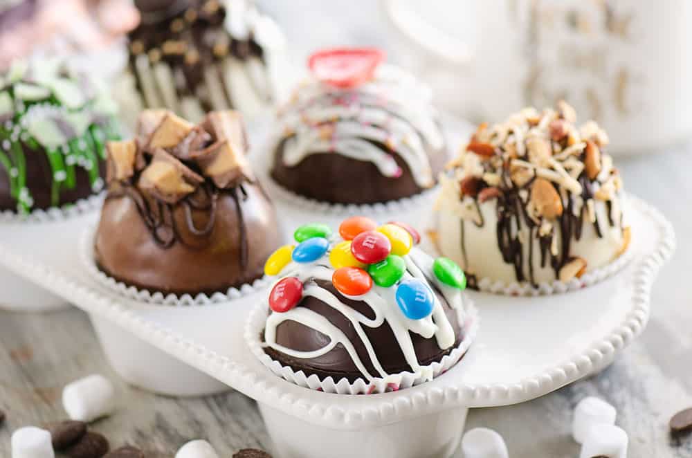 variety of hot cocoa bombs in muffin tin with hot chocolate mix