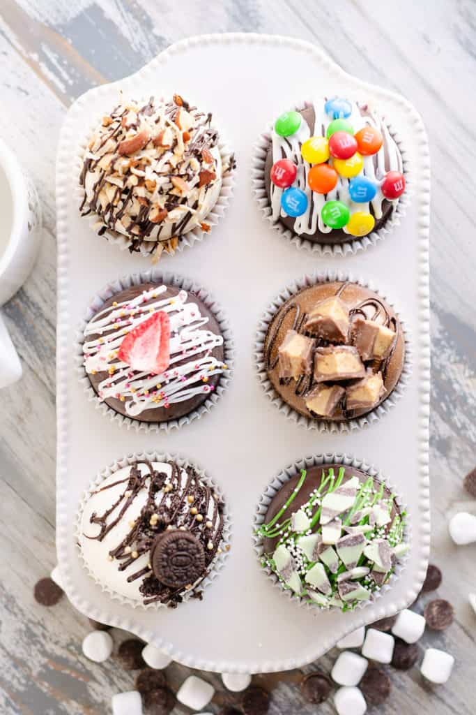 variety of hot cocoa bombs in muffin tin with hot chocolate mix