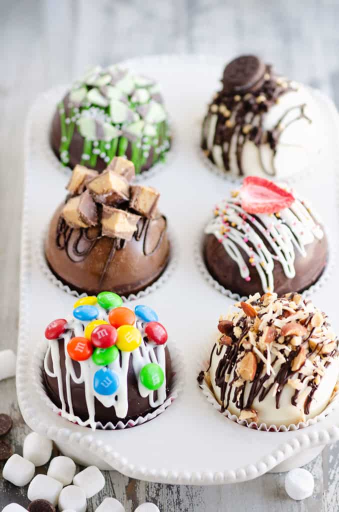 variety of hot cocoa bombs in muffin tin with hot chocolate mix
