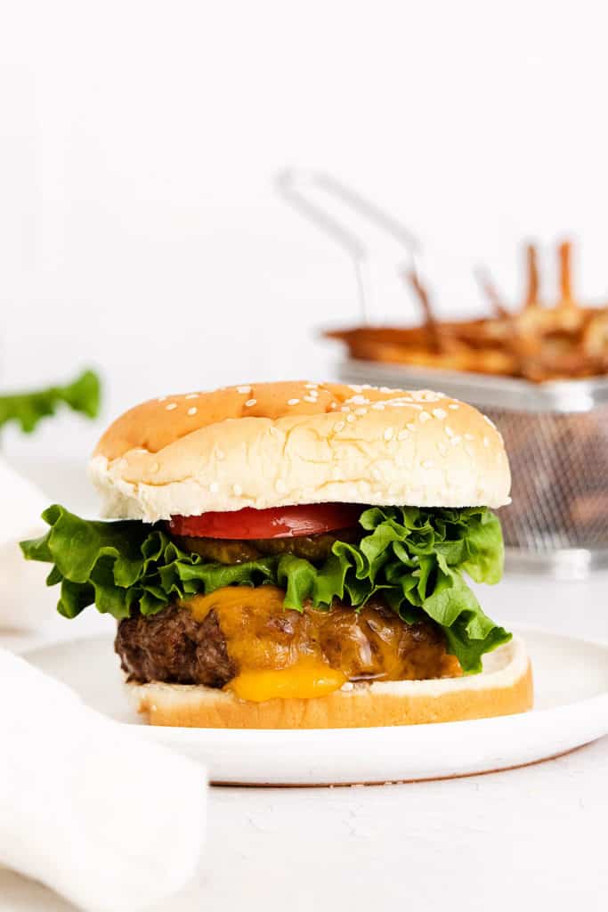 air fryer cheeseburger on plate served next to fries