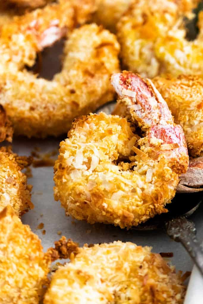 coconut shrimp on parchment lined sheet pan