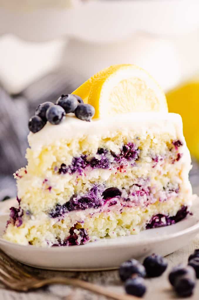 slice of layered blueberry lemon cake on plate