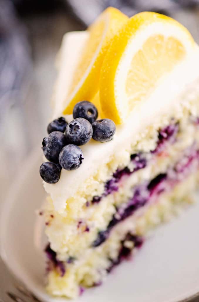 slice of layered cake topped with blueberries and fresh lemons