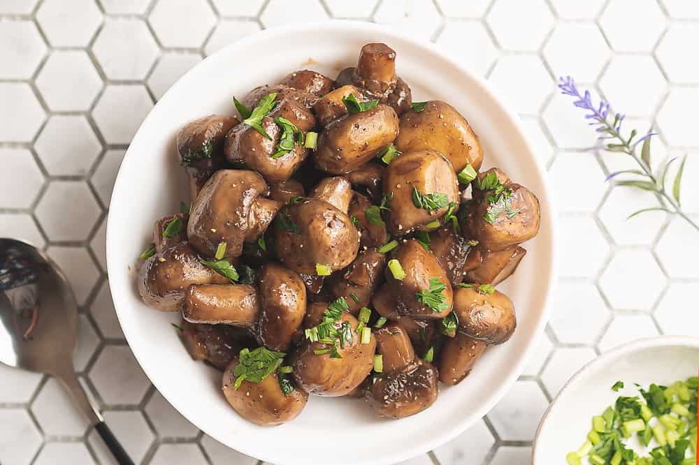 sauteed mushrooms topped with parsley in white bowl