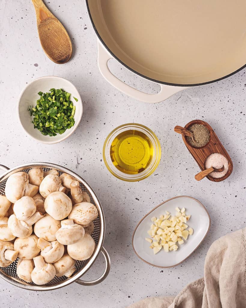 mushrooms, parsley, olive oil, galric, salt and pepper on table