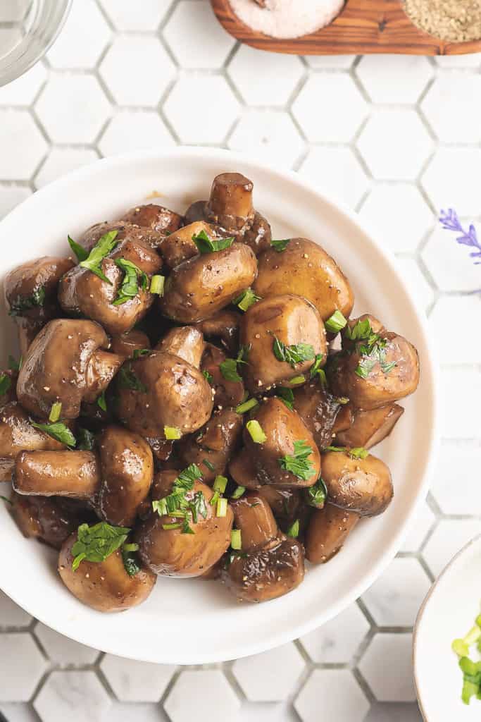 fresh mushrooms topped with parsley on tile table