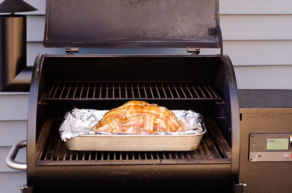 bacon wrapped ham in pan on Traeger pellet grill