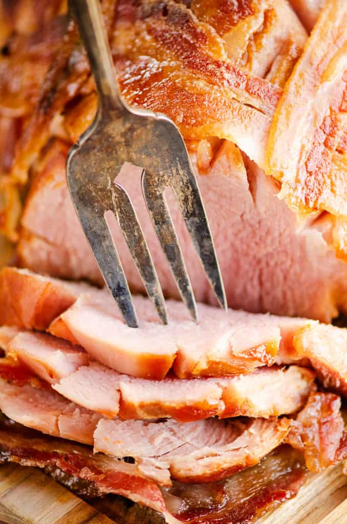 fork picking up slice of bacon wrapped ham