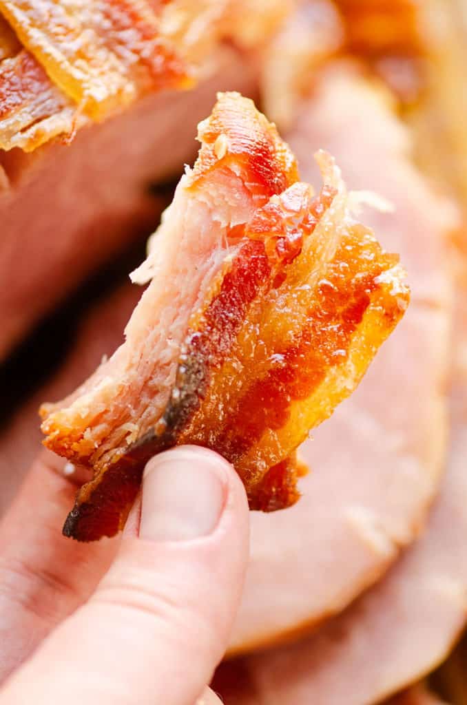 a piece of candied bacon and ham in hand