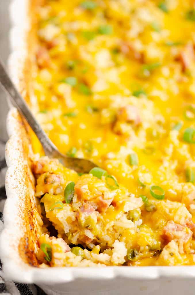 ham and rice casserole in white baking dish with spoon