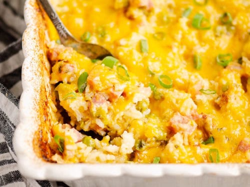 cheesy ham casserole with spoon scooping out ingredients