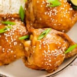 honey soy glazed chicken thighs garnished with sesame seeds and green onions