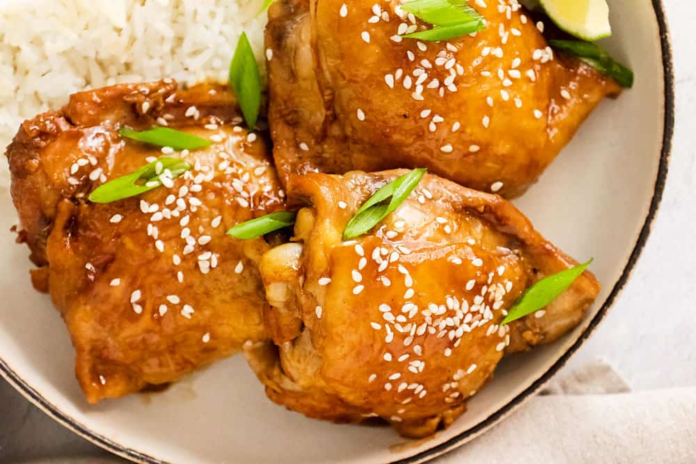 honey soy glazed chicken thighs garnished with sesame seeds and green onions