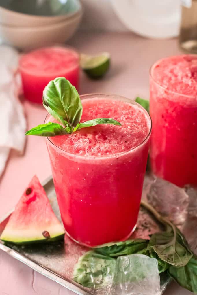 watermelon wine slushie in glass with wedge of watermelon on table