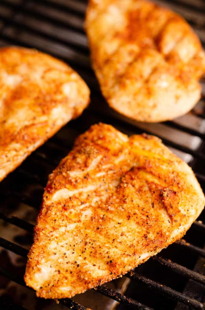 seasoned chicken breasts on smoker grill