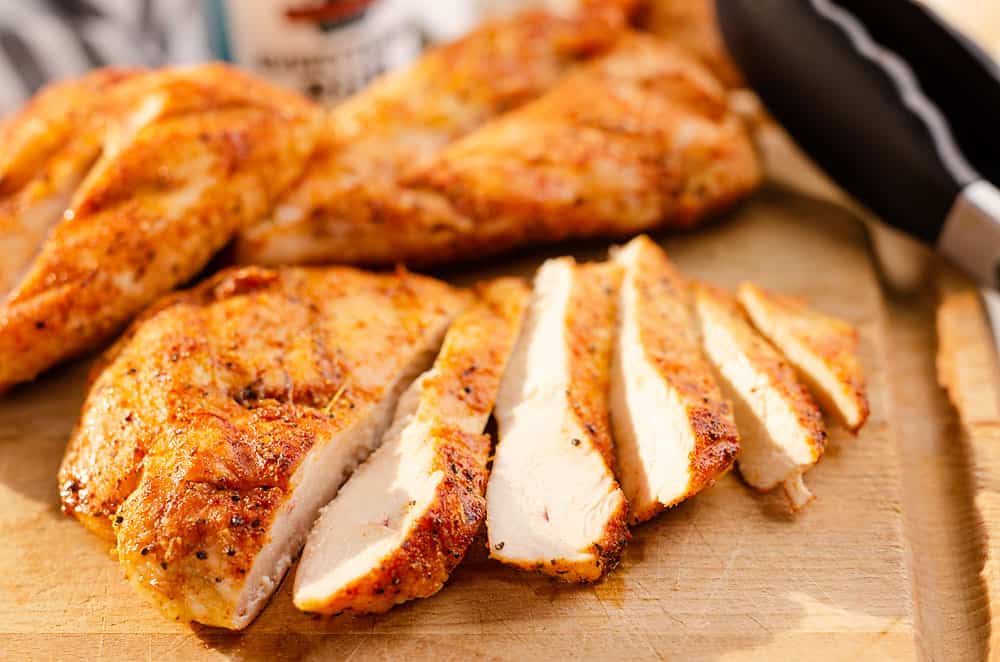 grilled chicken breast sliced on cutting board