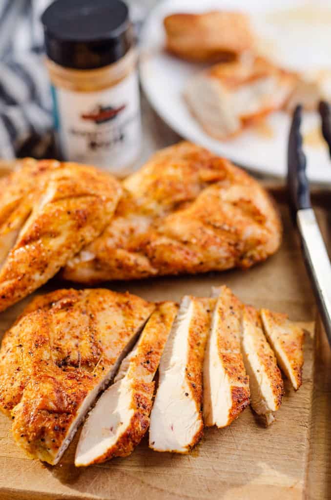 grilled chicken breast sliced on cutting board