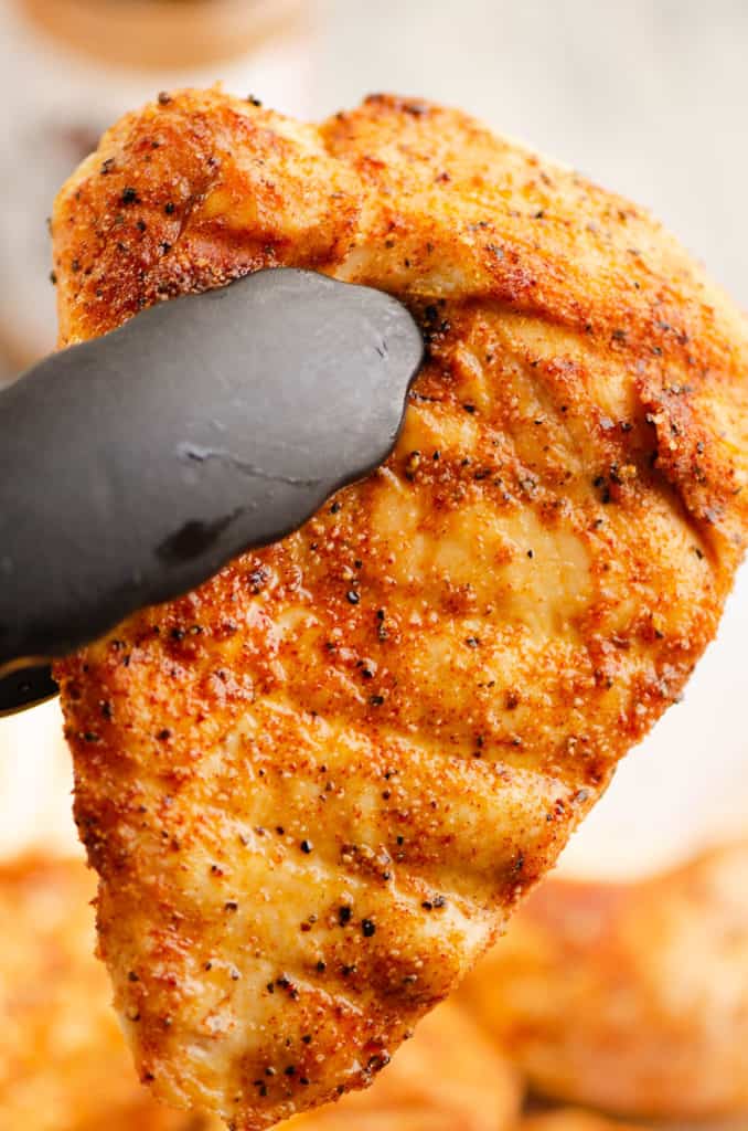 smoked chicken breast in tongs