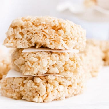 brown butter rice krispie treats stacked with parchment paper