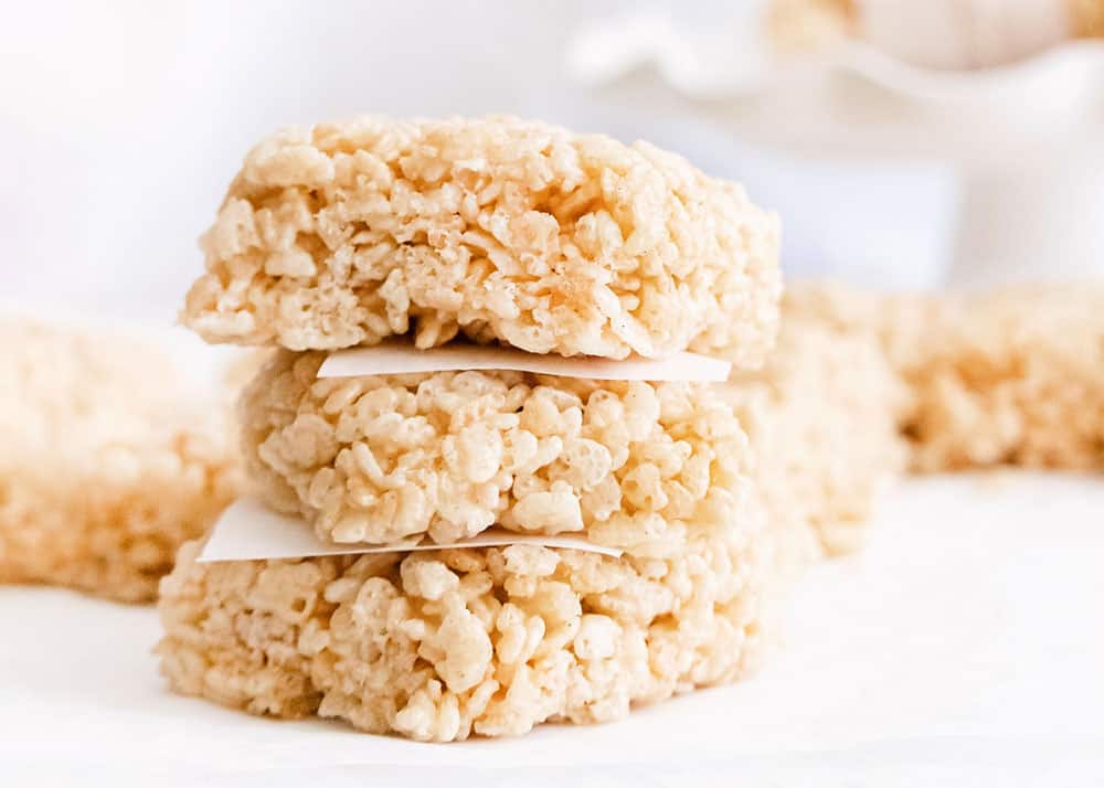 brown butter rice krispie treats stacked with parchment paper