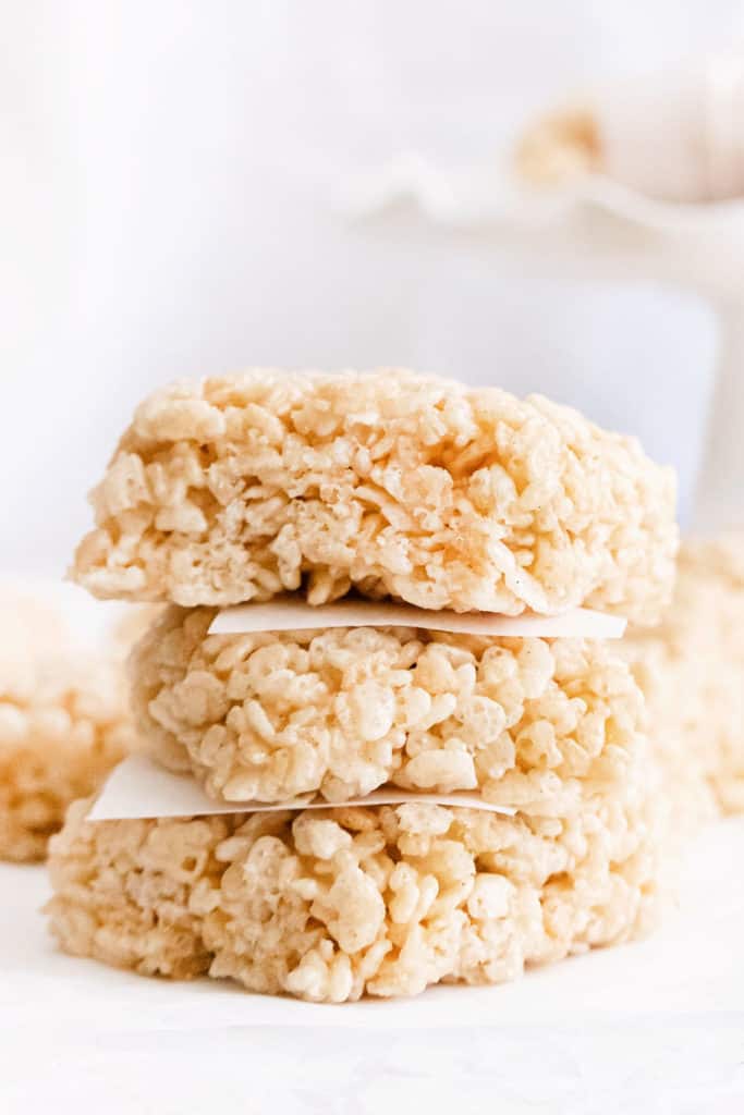 brown butter rice krispie treats stacked with parchment paper