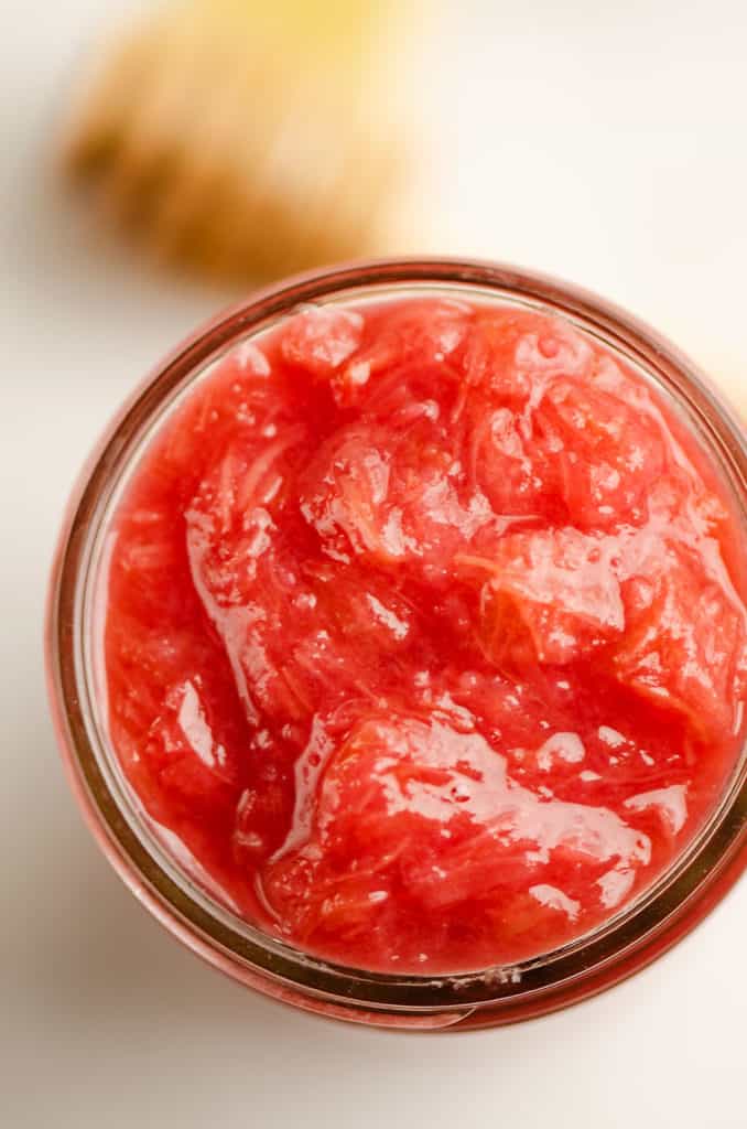 rhubarb sauce in glass jar with honey dipper