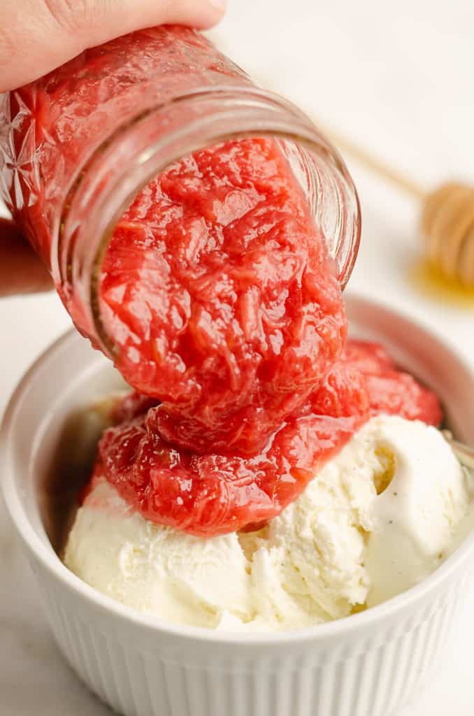 rhubarb honey sauce poured over ice cream in bowl