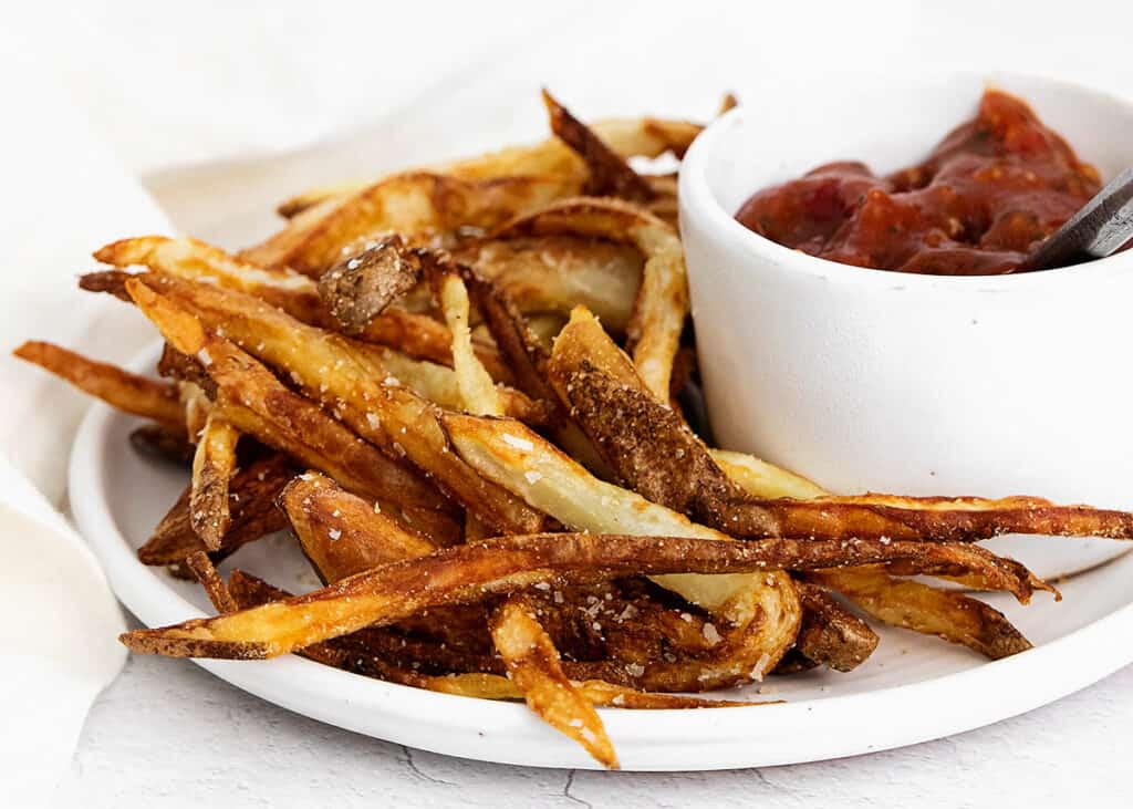 homemade french fries on plate with ketchup