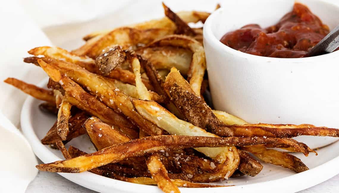 homemade french fries on plate with ketchup