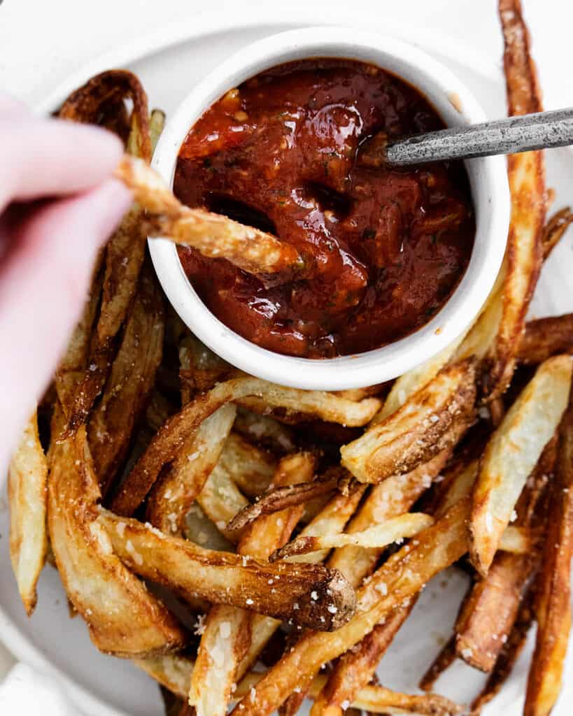 french fries dipped in sweet chili ketchup