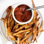 french fries on plate with bowl of ketchup