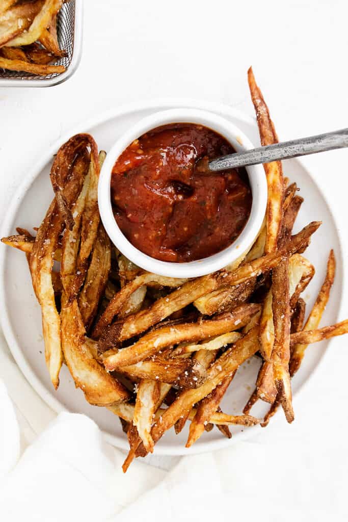 french fries on plate with bowl of ketchup