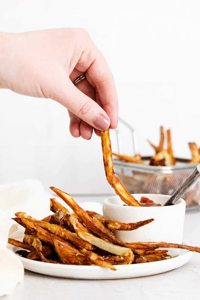 french fries dipped in bowl of ketchup