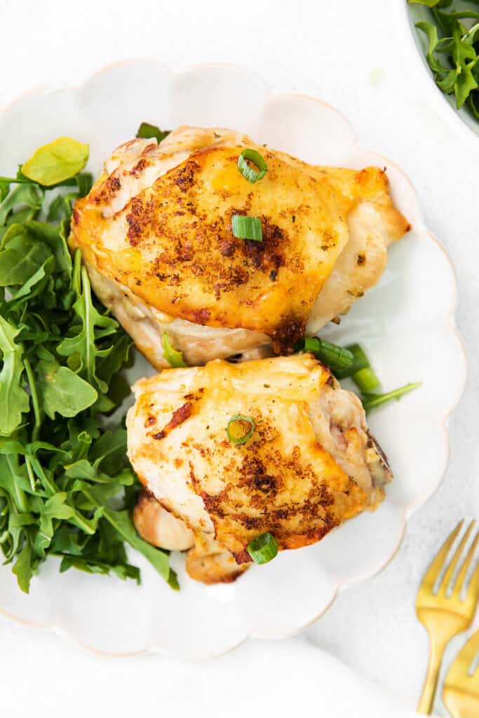 chicken thighs and salad on white plate