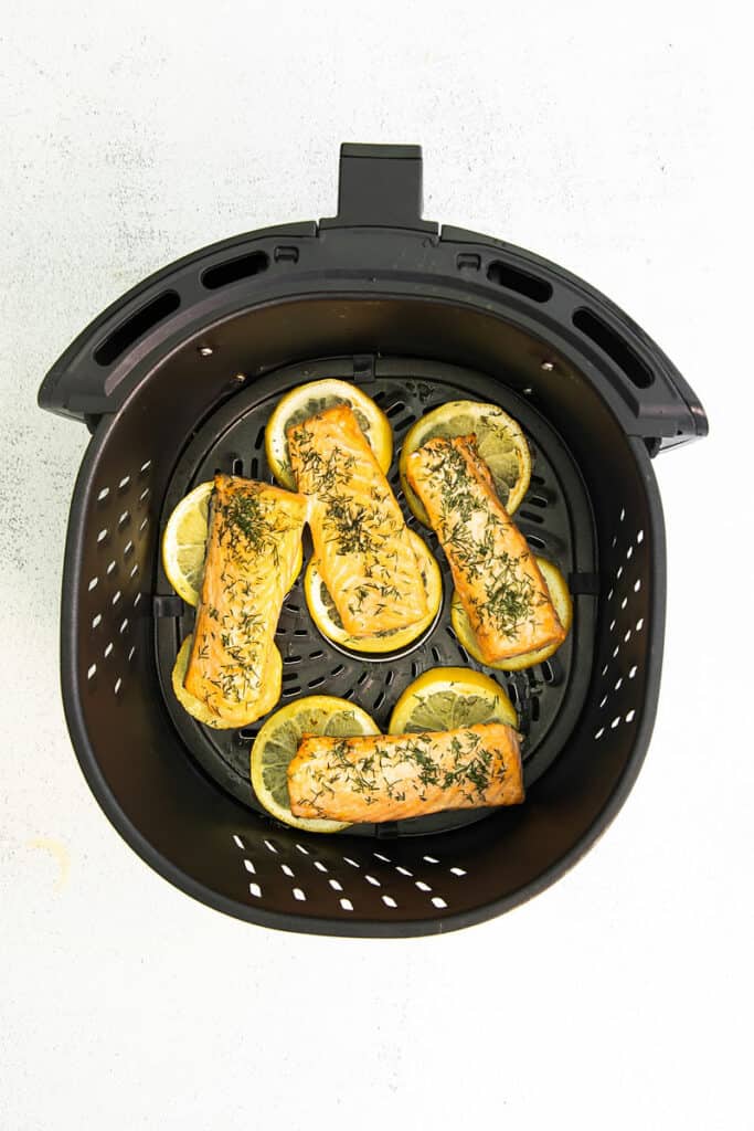 salmon cooked over lemon in air fryer basket