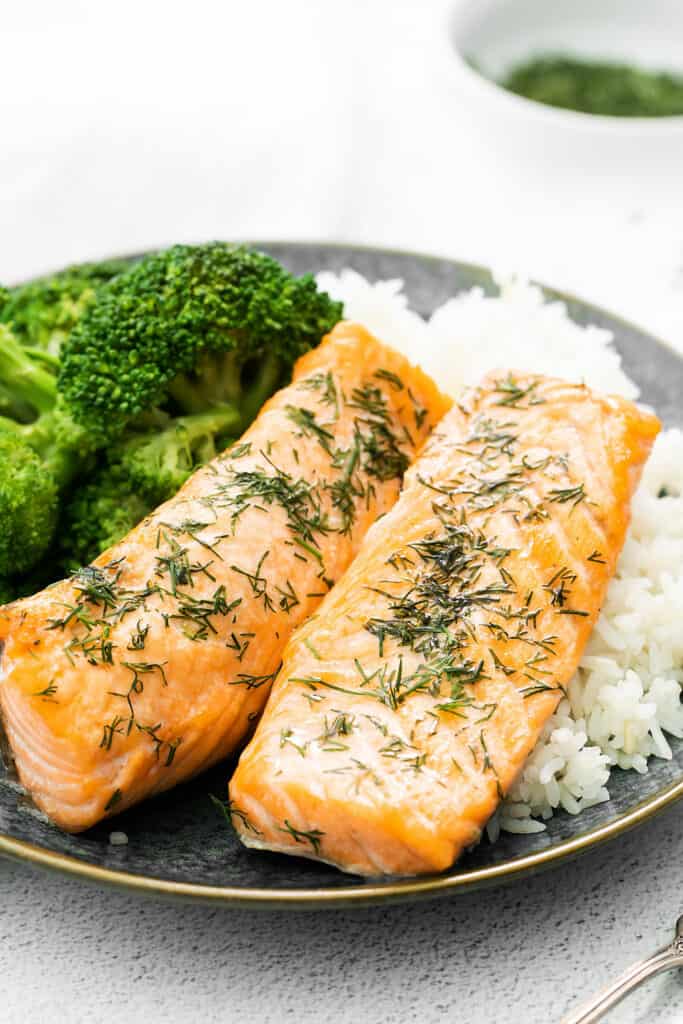 air fryer salmon fillets on plate with rice and broccoli