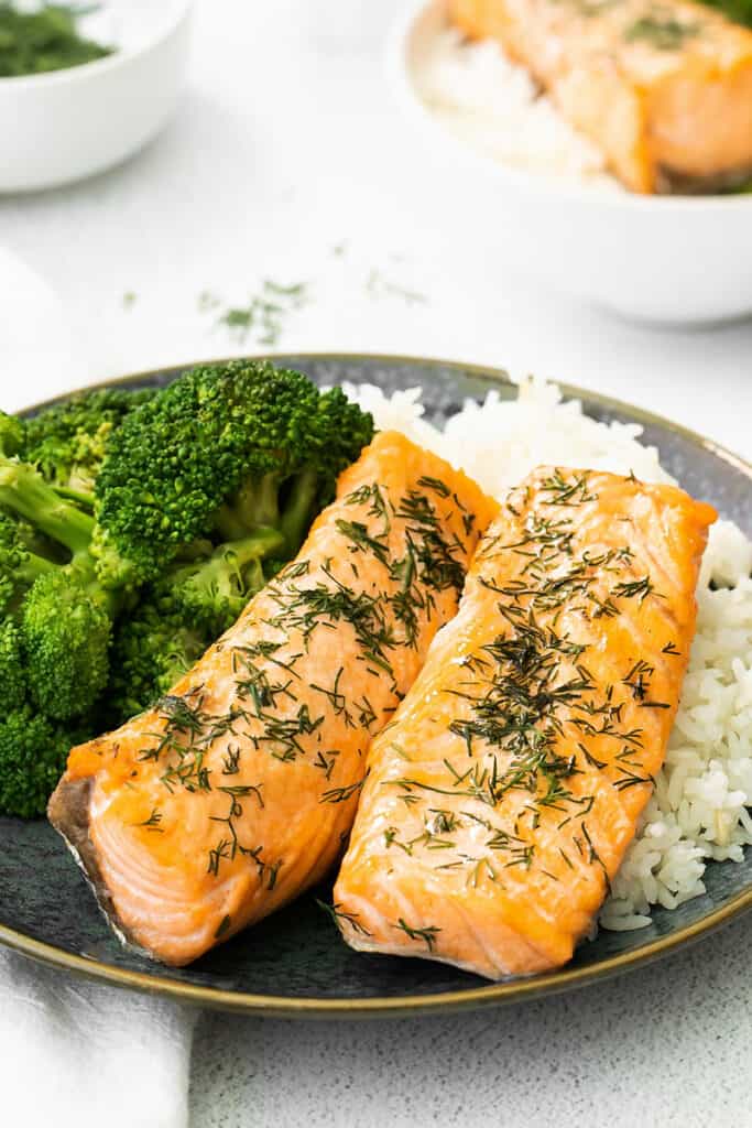 two lemon dill salmon fillets on dark plate