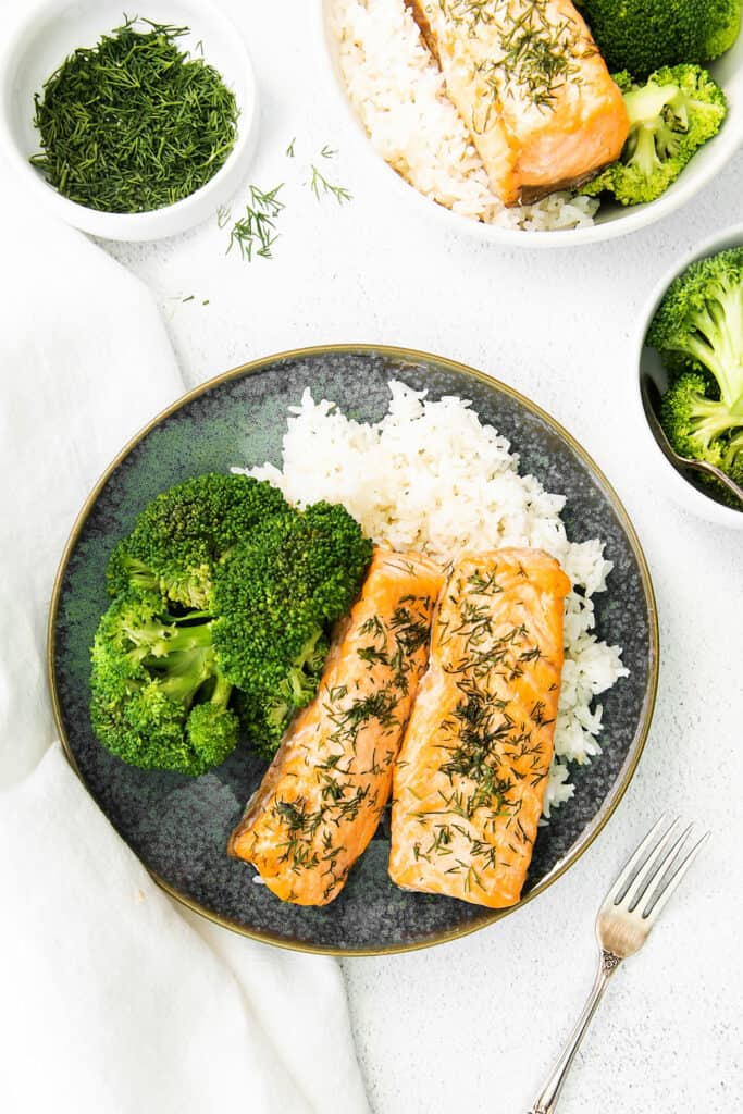 lemon dill salmon fillets on plate with rice and broccoli