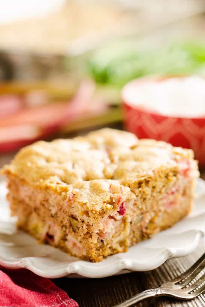 slice of rhubarb cinnamon cake on white plate with fork