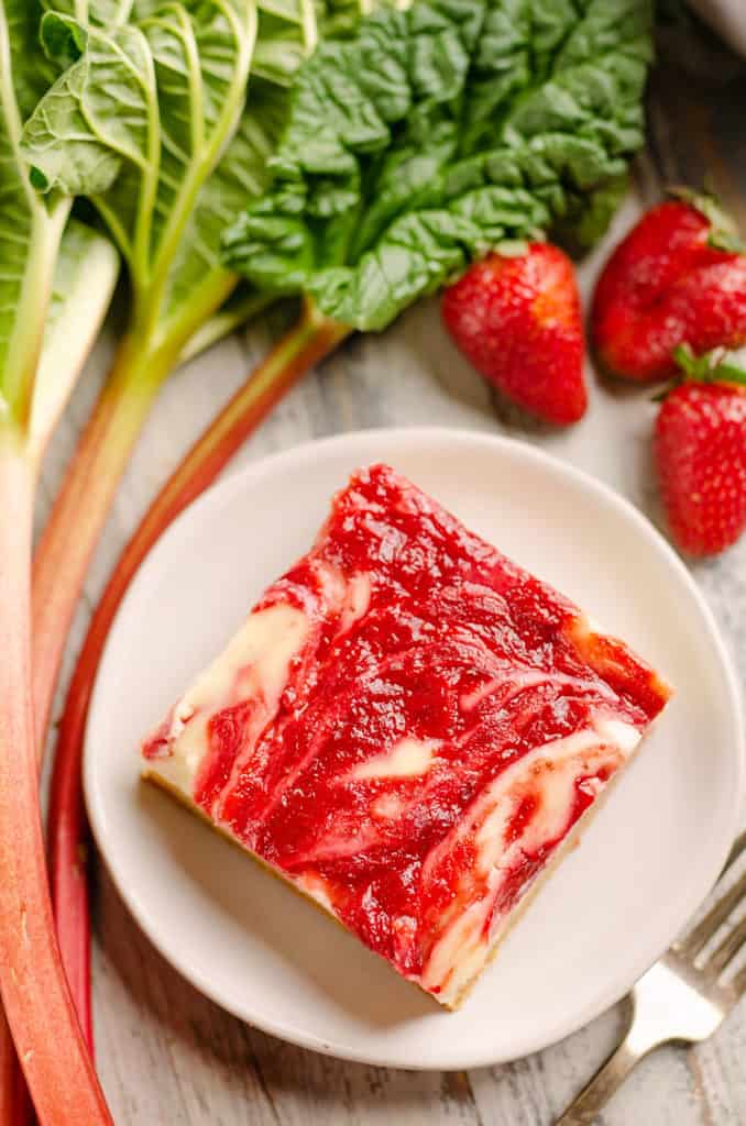 cheesecake swirl bar on plate with strawberries and rhubar