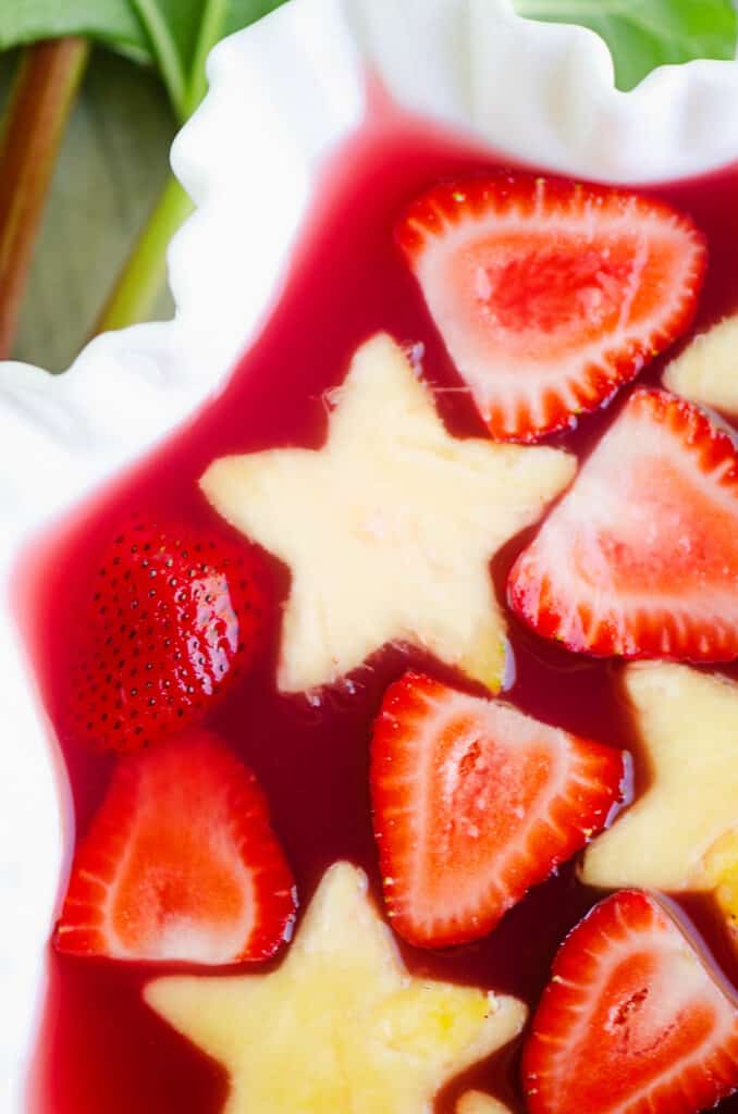 strawberry rhubarb punch in white bowl with fresh pineapple