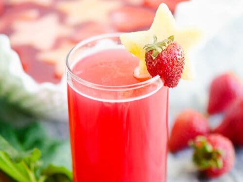 strawberry rhubarb punch in glass on table with strawberries