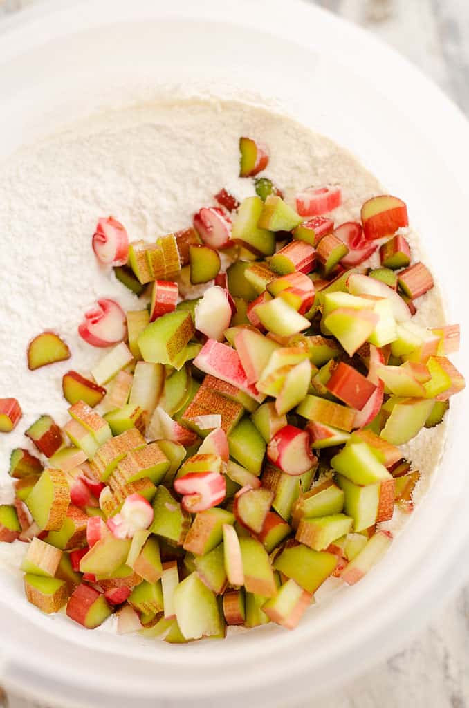 chopped rhubarb in plastic bowl with dry ingredients