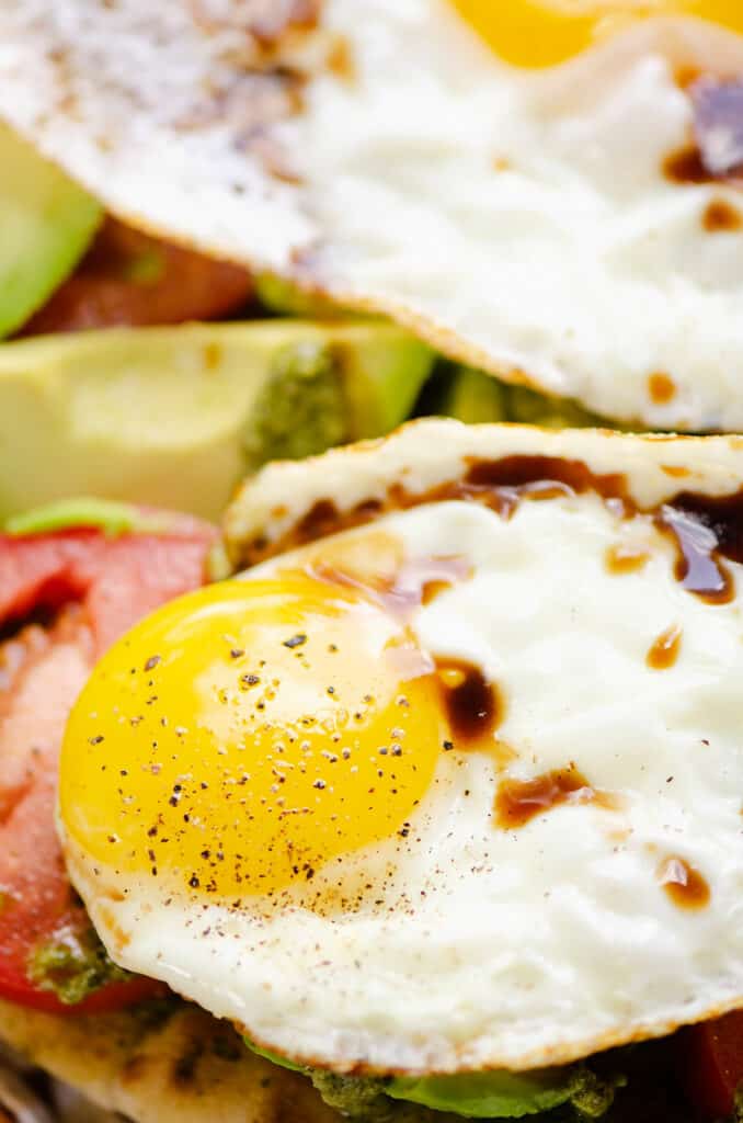 sunny side up egg drizzled with balsamic glaze over vegetables