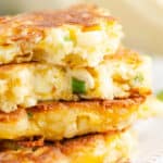 stack of corn fritters on plate with one broken in half