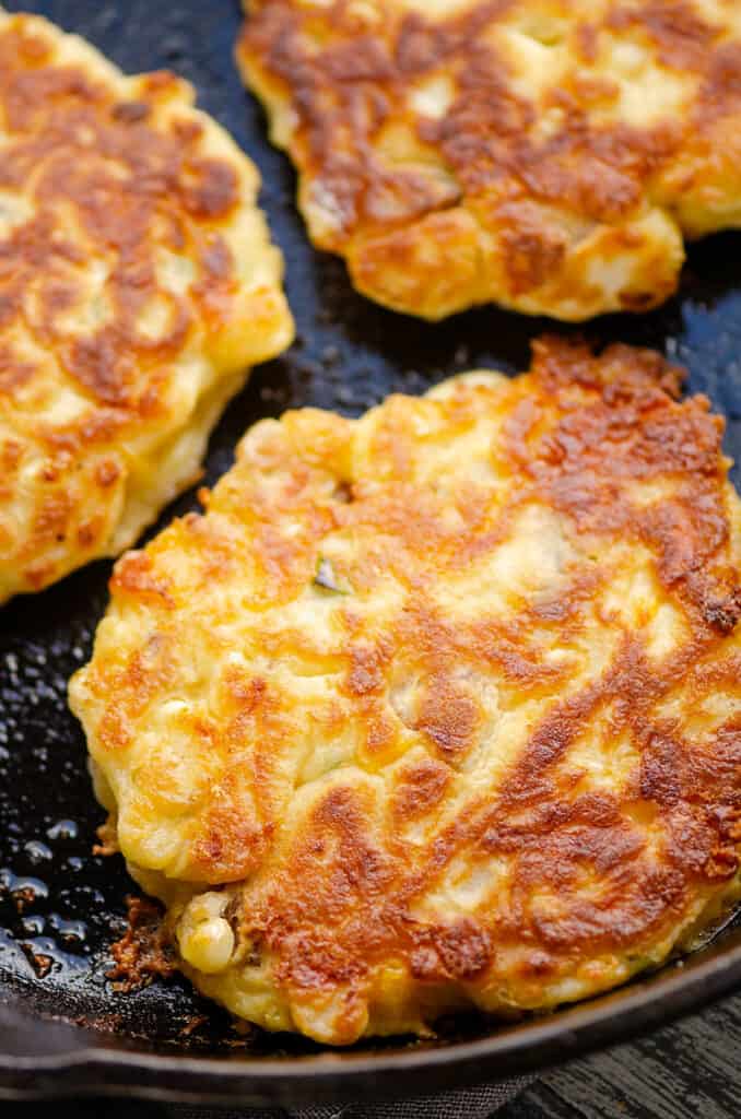 golden brown corn fritter in cast iron skillet